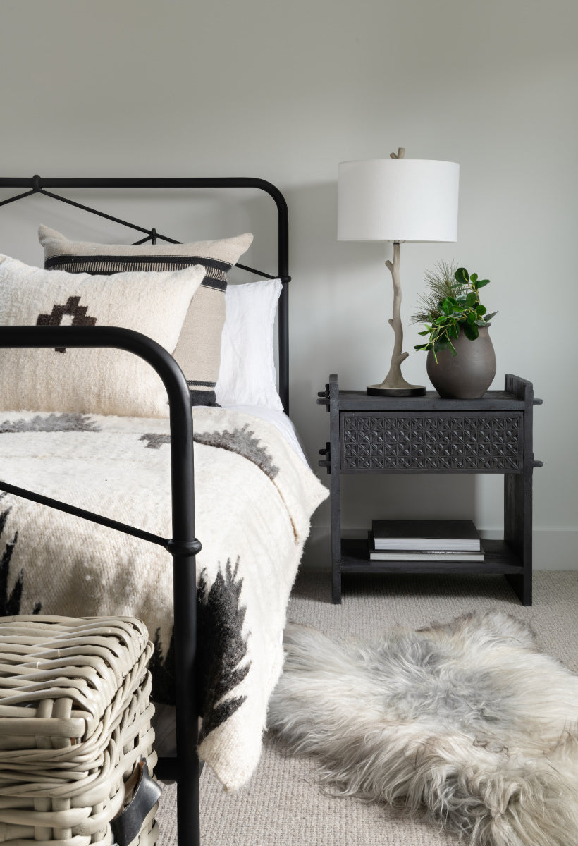 Guest bedroom with decorated bed and end table