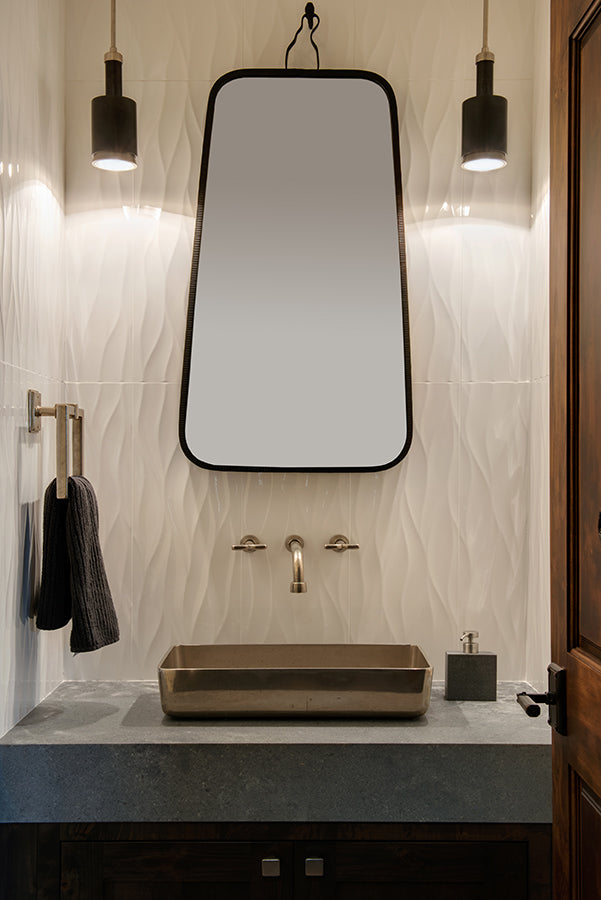 Elegant modern bathroom with textured backsplash and mirror