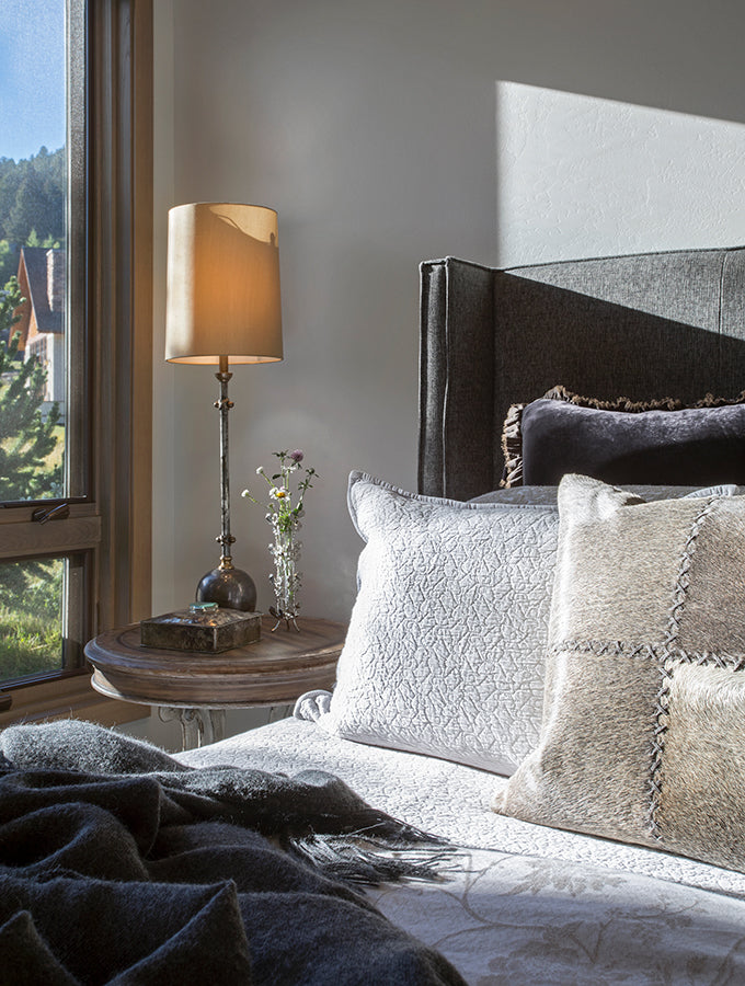 Elegant master bedroom with throw pillows and end table