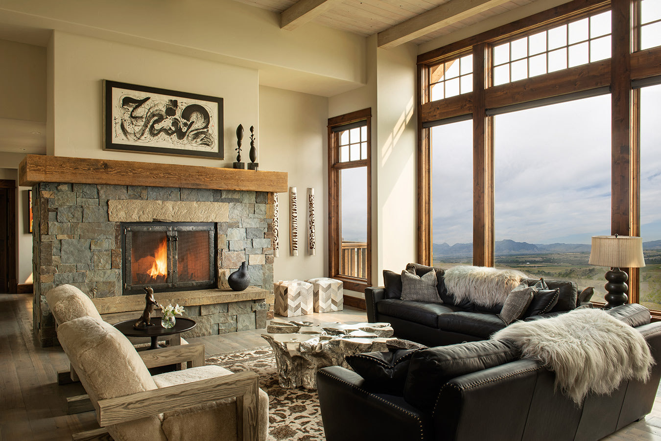 Cozy living room with stone fireplace and large window with incredible view