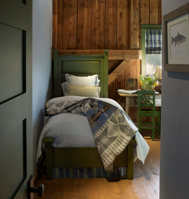 Twin bed in rustic restored barn bedroom