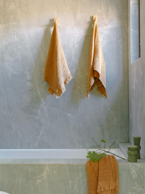 Orange Ella hand towels hanging in bath