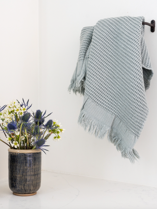 Ella hand towel on rack with a potted flower