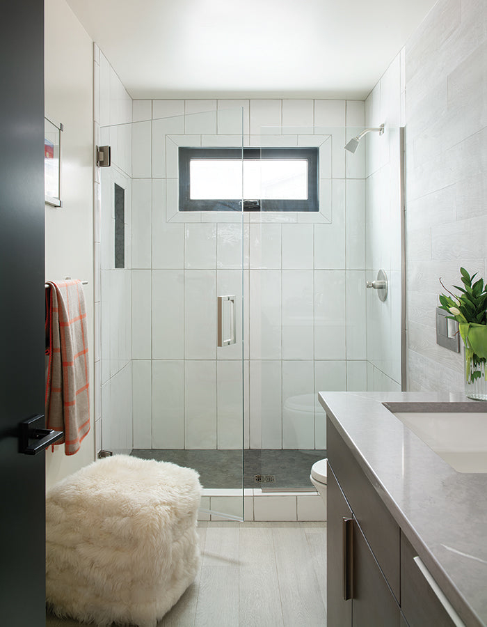 Modern bathroom with glass shower and large vertical subway tile