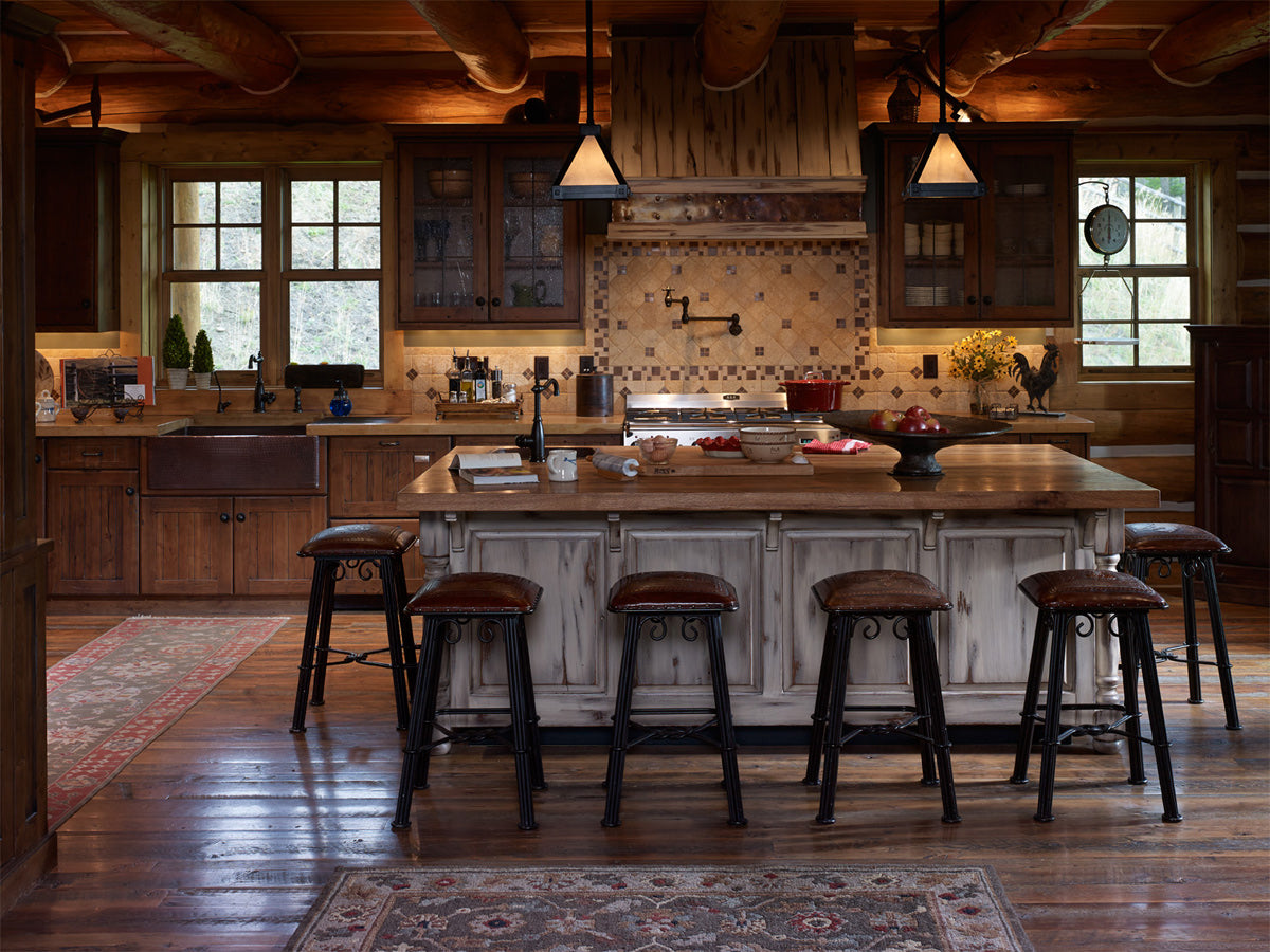 Kitchen with large island and barstools, rustic cabinetry with ornate backsplash