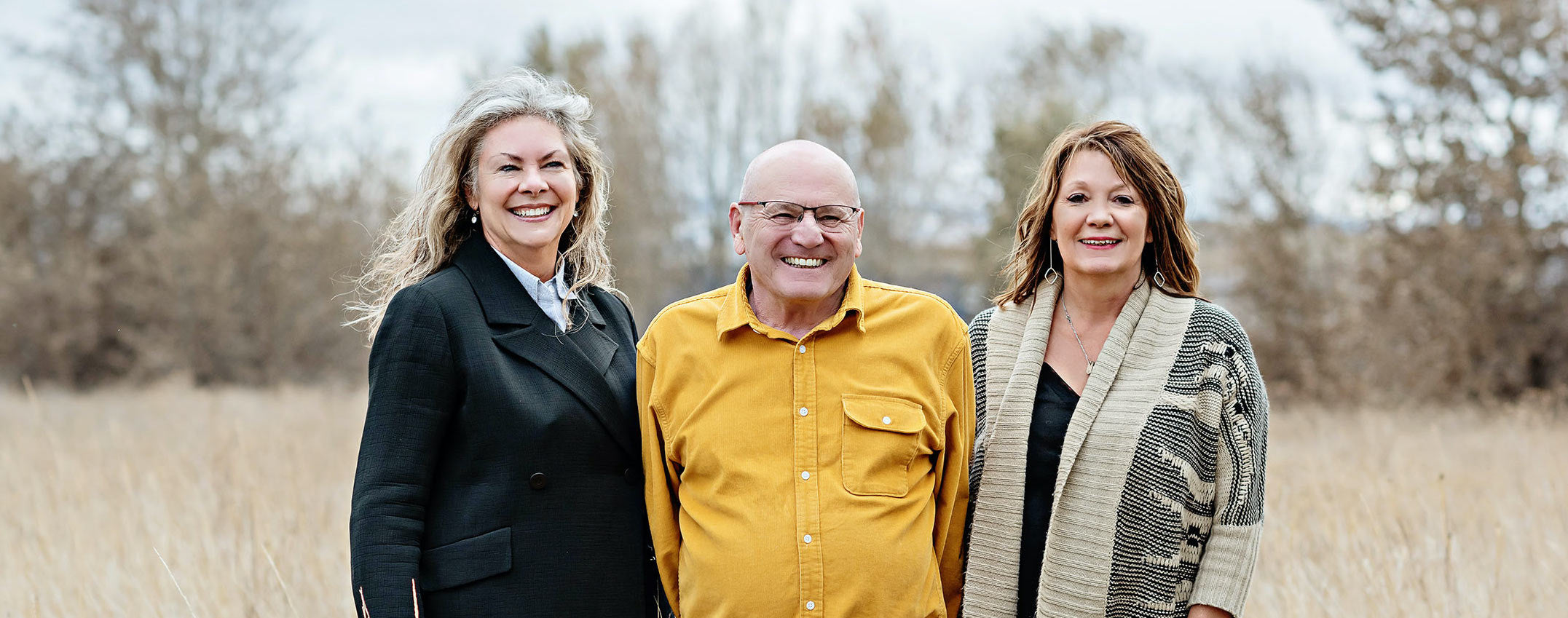 Kathy Koelzer, Ralph McHenry, and Barbara Diekman standing in a field