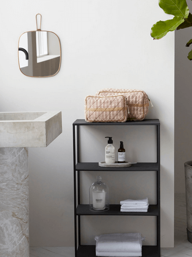 Terracotta and sand toiletry and makeup bags in bathroom
