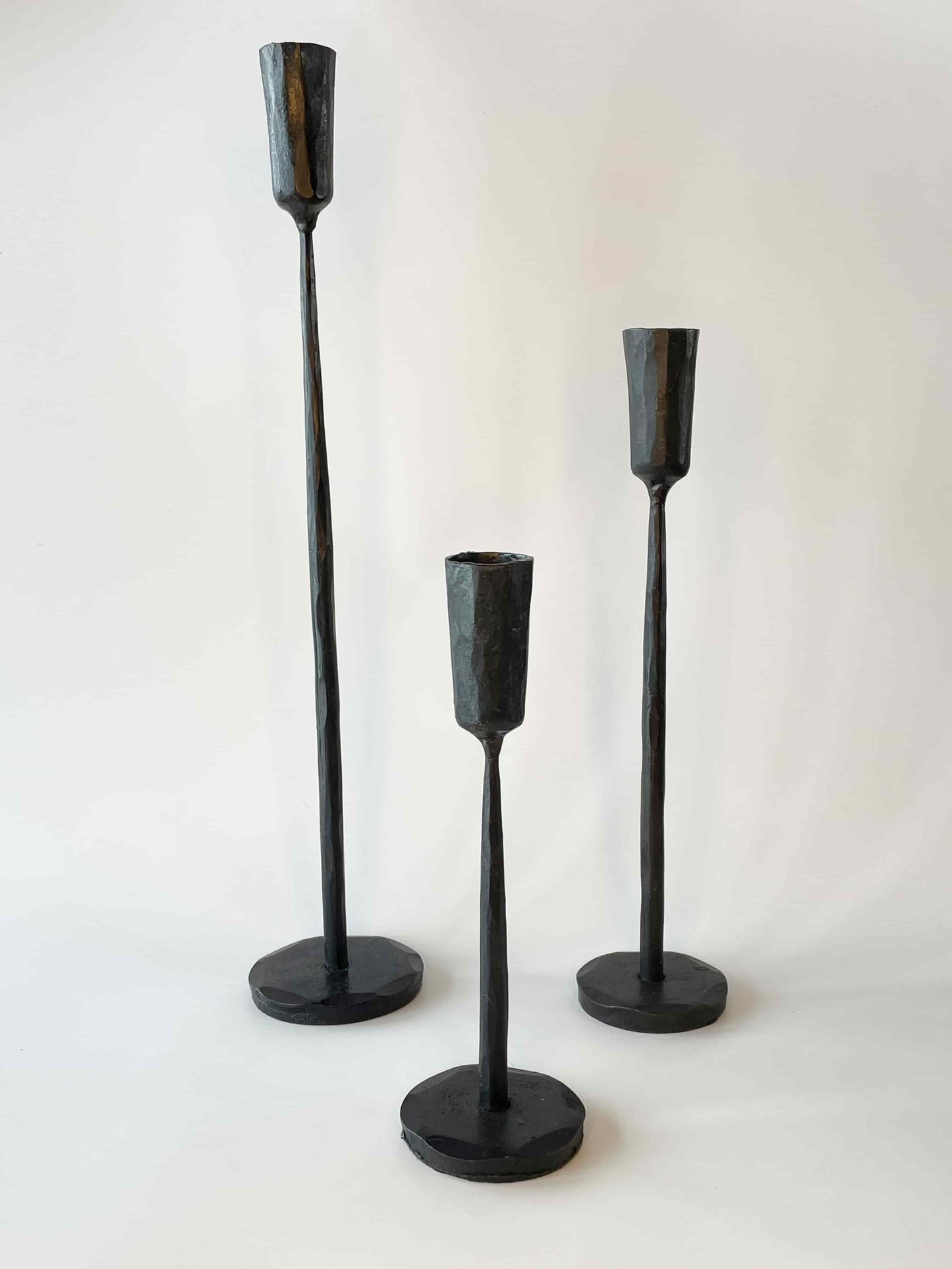 Three textured black tapered candle holders