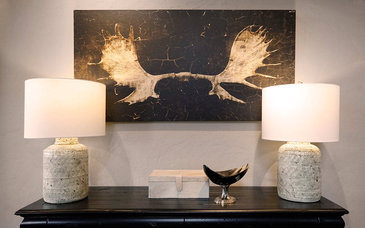 Moose antler wall art behind a decorated buffet table with two lamps